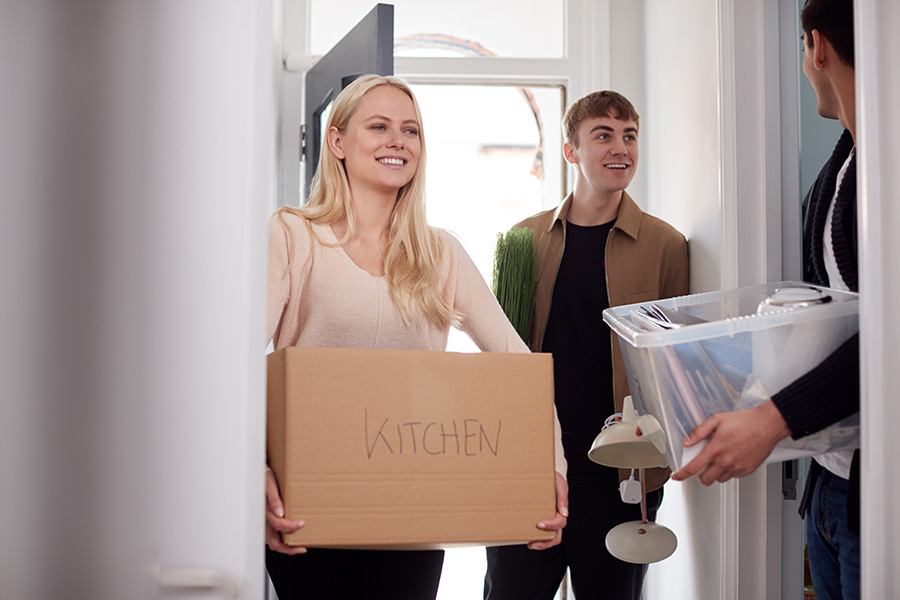 Off-Campus Student Housing Insurance - A Group of College Students Carrying Boxes and Moving into an Off-Campus Accommodation Together