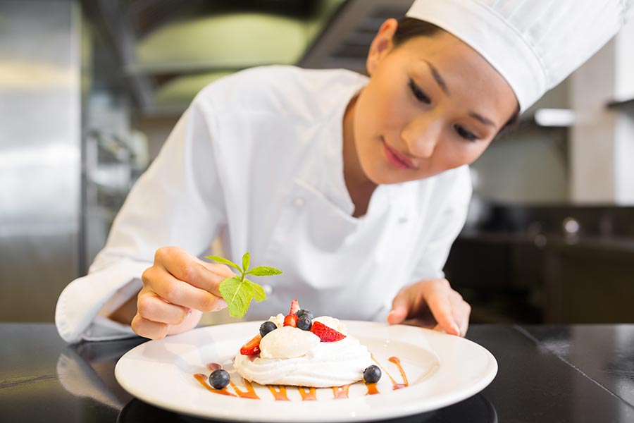 Specialized Business Insurance - Professional Chef Plating a Dish, Smiling